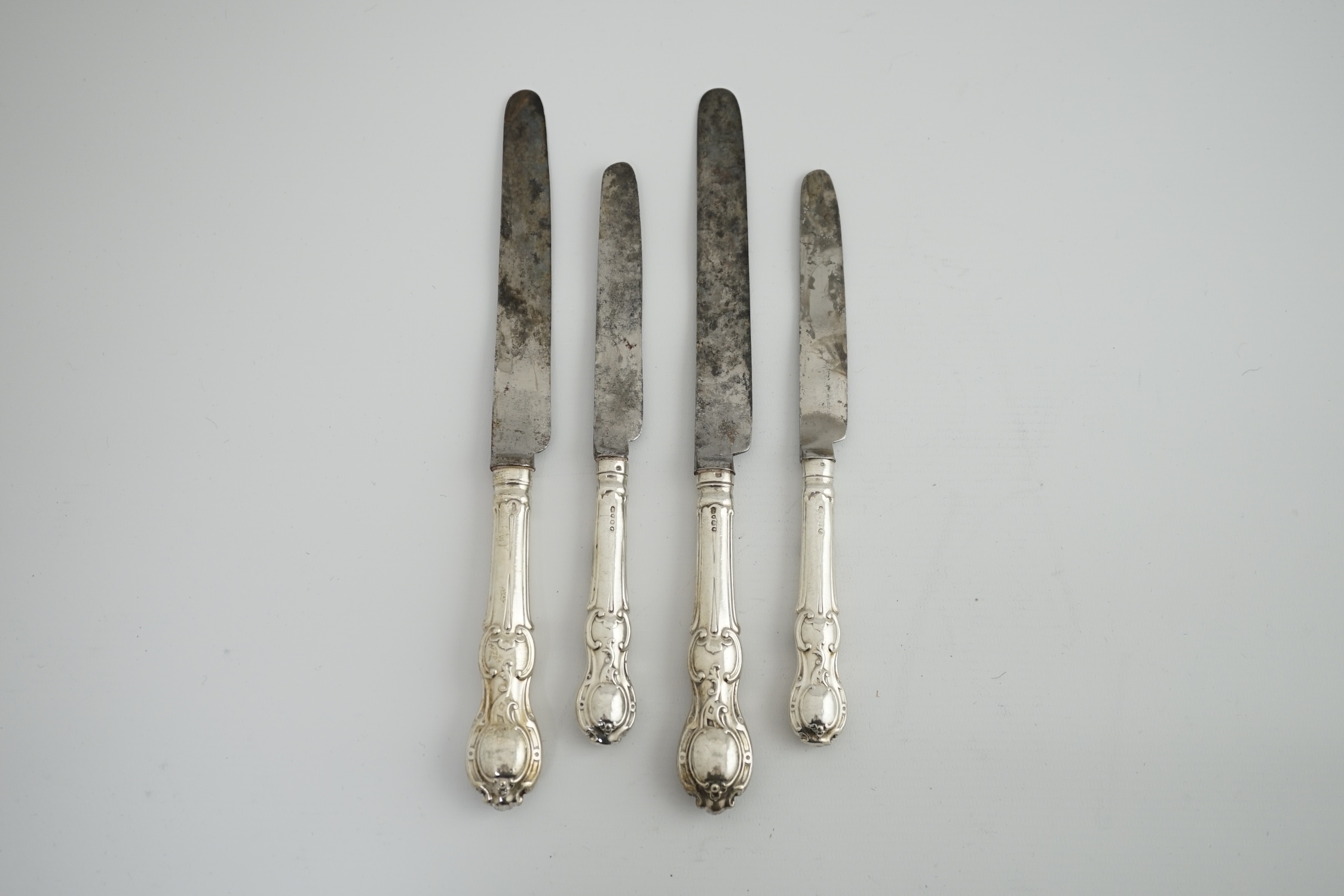 A matched set of nine Victorian silver rococo handled table knives, with steel blades, and eight matched Victorian silver rococo handled dessert knives.